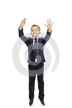 Boy in school uniform jumping, isolated on white background