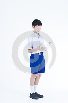 A boy in a school uniform is reading a book on the white background