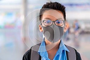 Boy in school uniform wearing a surgical mask with blurred background, Virus protection concept