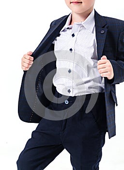 Boy in a school uniform on a white background. The boy demonstrates a black jacket.