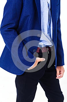 Boy in a school uniform on a white background. The boy demonstrates a blue jacket.