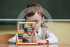 Boy in school working with abacus