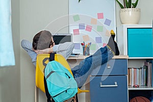 Boy Schoolboy Does Homework In sitting at a table at home. Back to school. Home study setting