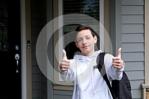 boy schoolboy shows thumbs up shows with both hands thumbs down spreads arms to sides What to do on shoulder backpack