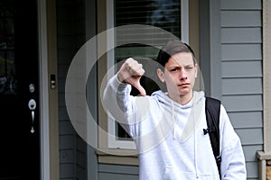 boy schoolboy shows thumbs up shows with both hands thumbs down spreads arms to sides What to do on shoulder backpack