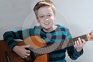 Boy schools himself to play the  acoustic guitar