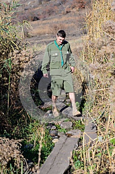 Boy Scout Crossing Creek on Wood Plank Footbridge