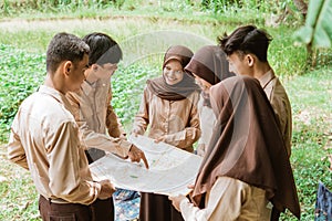 boy scout with finger pointing at map with group mates