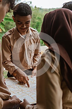 boy scout with finger pointing at map while standing