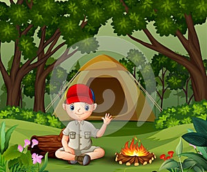 Boy scout sitting near the campfire