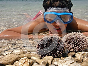 Boy in sea with sea urchins