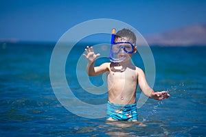 A boy in a sea with a swimming mask and snorkel