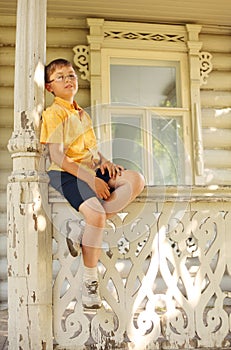 Boy seat on handrails on terrace photo
