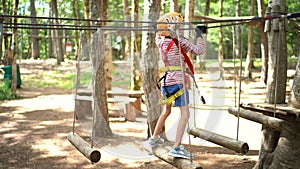 Boy on a security line clambering on an agility bridge in adventure park