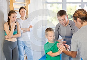 Boy in self-defense class tries to perform method of neutralizing enemy by wringing hand.