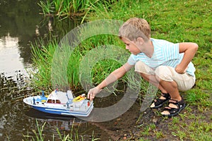 Boy sends toy ship in floating