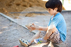 Boy shakes the sand out of the shoe photo