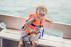 A boy on a ship with an action camera is ready for snorkeling