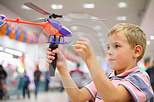 Boy in shop with toy helicopter