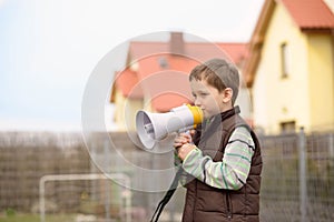 Boy shouts something into the megaphone