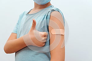 Boy showing arm with bandage. Virus protection. COVID-2019. Coronavirus vaccination campaign