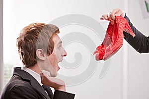 Boy showing happiness when seeing pair of red shoes