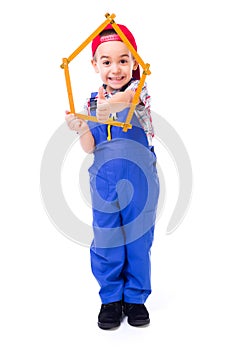 Boy showing thumbs up through house made of measuring ruler