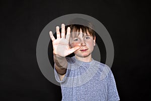 Boy shows his hand to stop