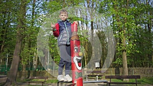 Boy shows like gesture standing on a wooden totem