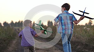 Boy siblings run past fields to launch airplanes to sky