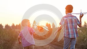 Boy siblings run past fields to launch airplanes to sky