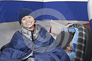 Boy With Sister Relaxing In Tent