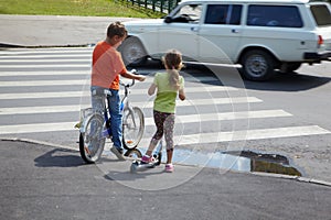Boy and sister stand before zebra crossing photo
