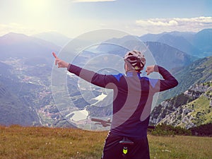 Boy sit on mountain bike and watching from Alps peak