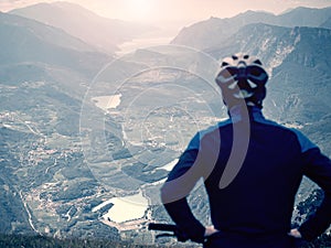 Boy sit on mountain bike and watching from Alps peak