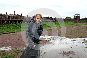 Boy siting on stone in viking village