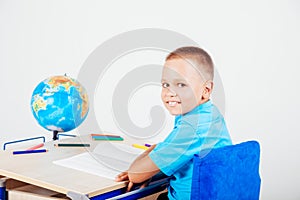 Boy sits at his desk and doing homework