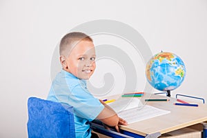 Boy sits at his desk and doing homework