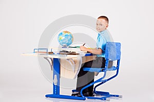 Boy sits at his desk and doing homework