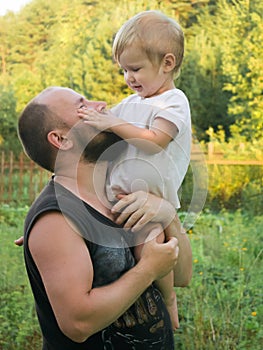 The boy sits on his father`s shoulder