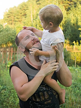 The boy sits on his father`s shoulder