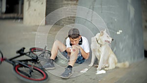 The boy sits in the park after falling off a bicycle, calms the pain in his knee, represents a dangerous bike riding