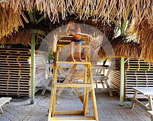 Boy sits on a rescue tower