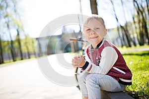 Boy sits on road afternoon