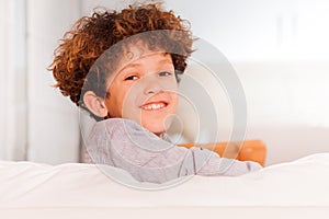 Boy sitting backwards on white sofa in lounge room