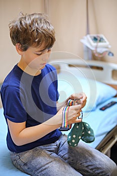 Boy sitting on a bed and holding a special cap for