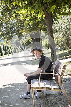 Boy sitting on a bench in a park