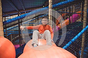 Boy sitting on big ball at in door playground