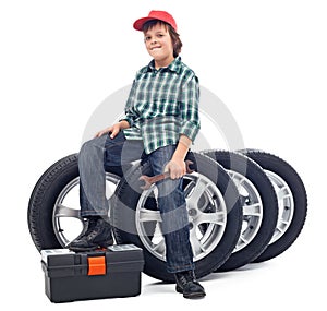 Boy sitting on car tires