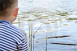 Boy Sitting in Chair and Fishing Amongst the Reeds